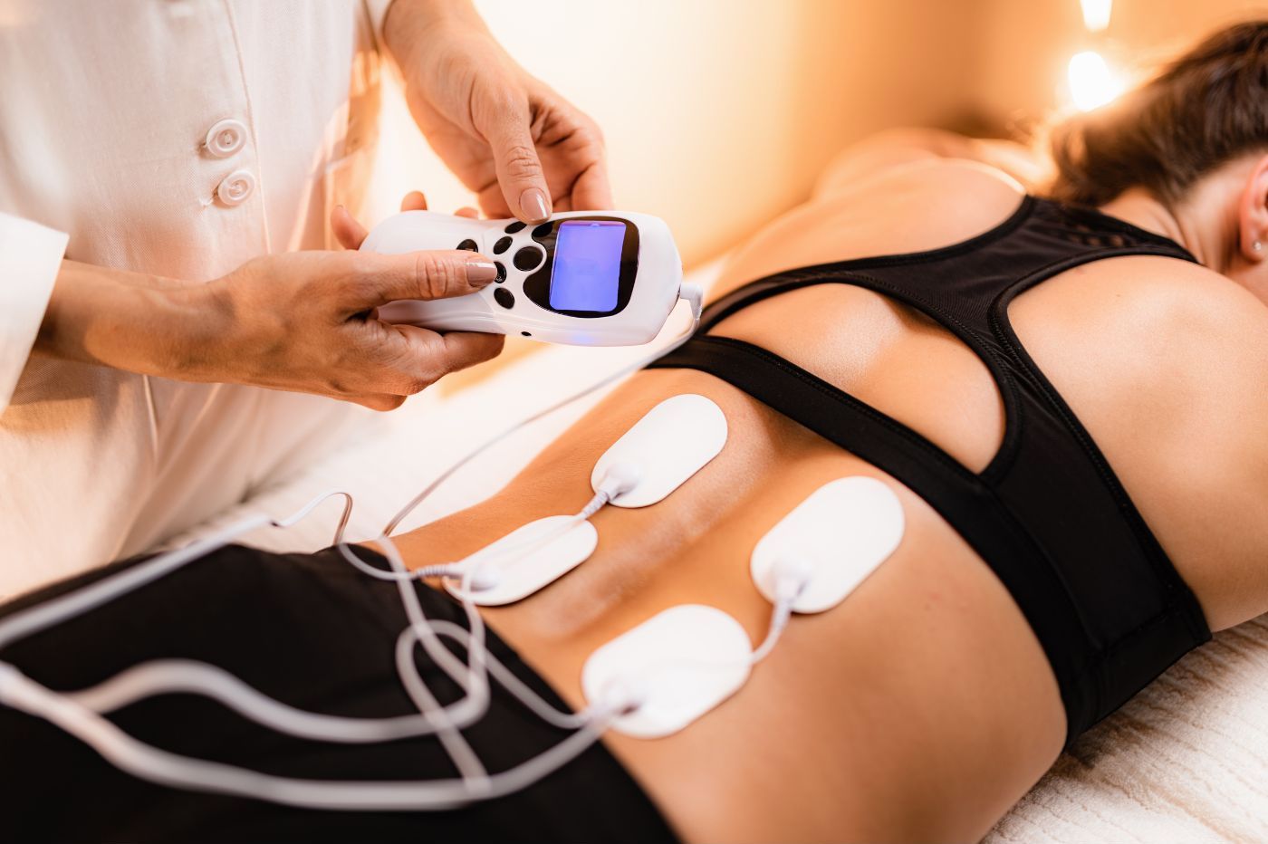 A woman undergoes chiropractic therapy at the Manhattan Chiropractic Center, where a therapist uses a TENS (transcutaneous electrical nerve stimulation) device on her back, with electrodes attached to her A woman undergoes chiropractic therapy at the Manhattan Chiropractic Center, where a therapist uses a TENS (transcutaneous electrical nerve stimulation) device on her back, with electrodes attached to her